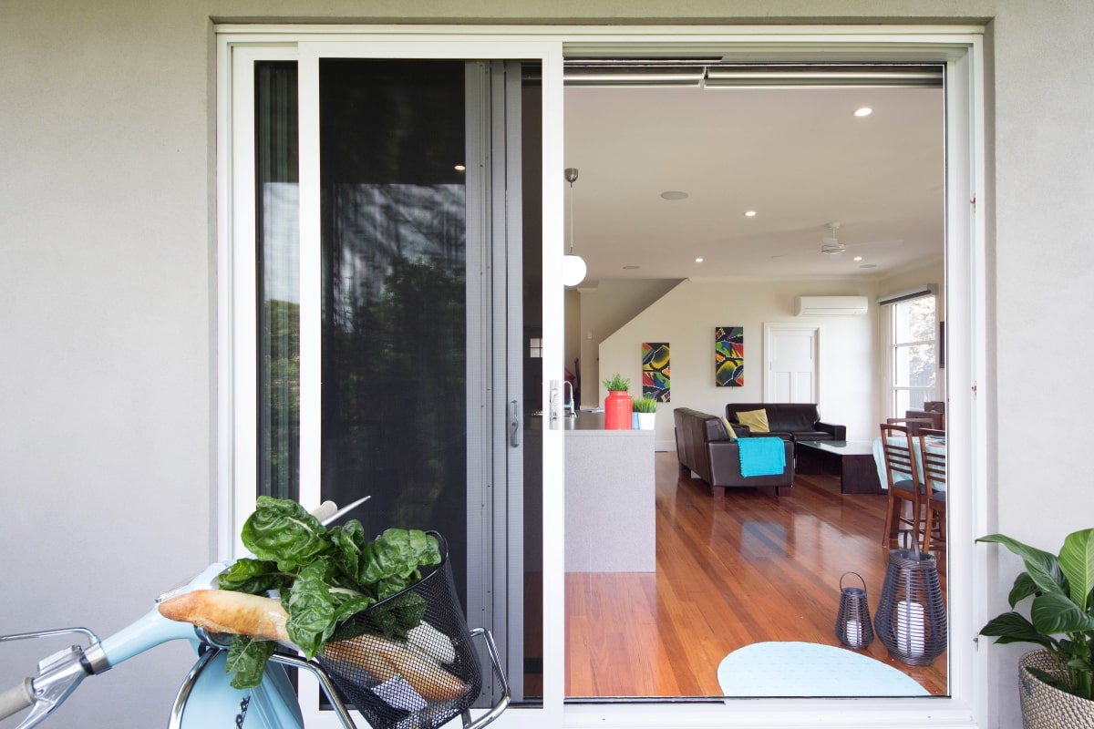 A home with an open sliding door and Vespar in the foreground.